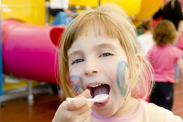 Mangiare cucchiaio divertente ragazza parco giochi sorridente bionda — Foto Stock