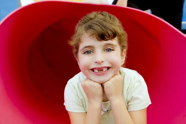 Morena chica dentada sonriendo en el patio rojo —  Fotos de Stock
