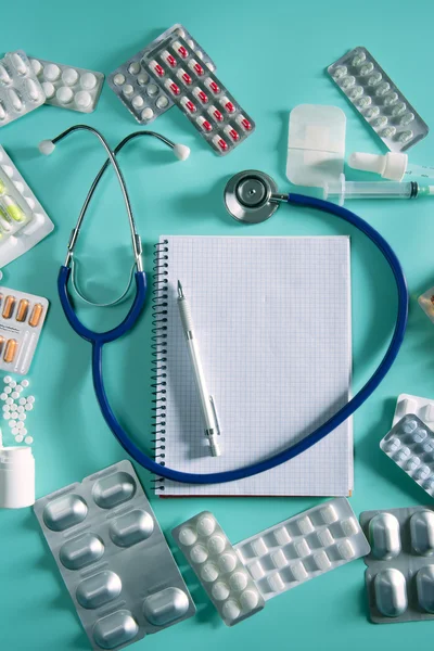 Läkare desk arbetsplatsen stetoskop spiral notebook — Stockfoto