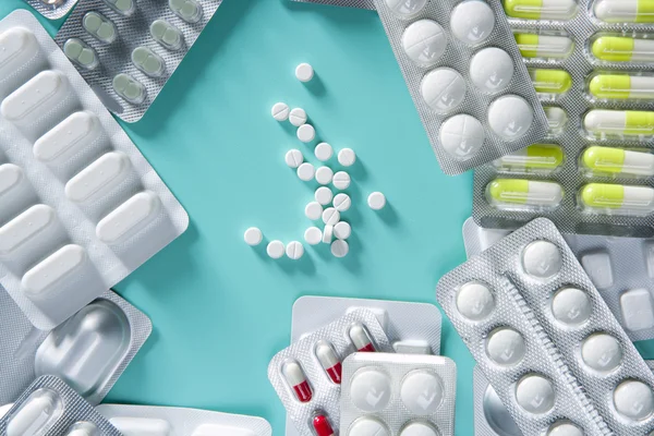 Blister pílulas médicas fundo mesa verde — Fotografia de Stock