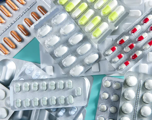 Волдыри медицинские таблетки фон зеленый стол — стоковое фото