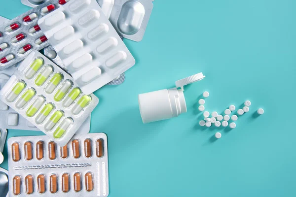 Blister pills silver over green open white bottle medica — Stock Photo, Image