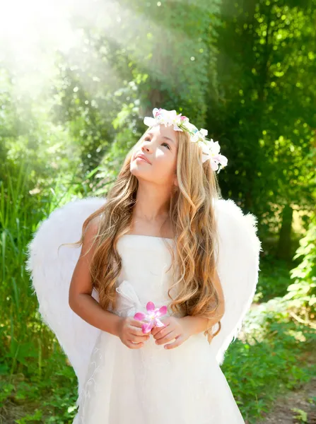 Ängel barn flicka i skogen med blomma i handen — Stockfoto
