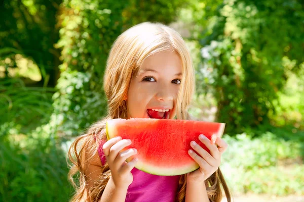 Barn blond liten flicka äter vattenmelon slice i skogen — Stockfoto