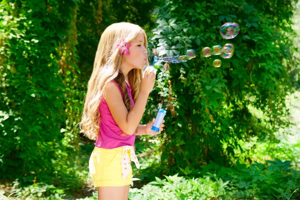 Дети выдувают мыльные пузыри в открытом лесу — стоковое фото