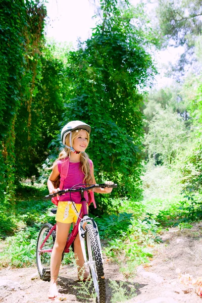 Kinderen meisje paardrijden fiets buiten in het bos glimlachen — Stockfoto