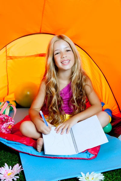 Kinderen meisje schrijven notebook op camping tent met bloemen — Stockfoto