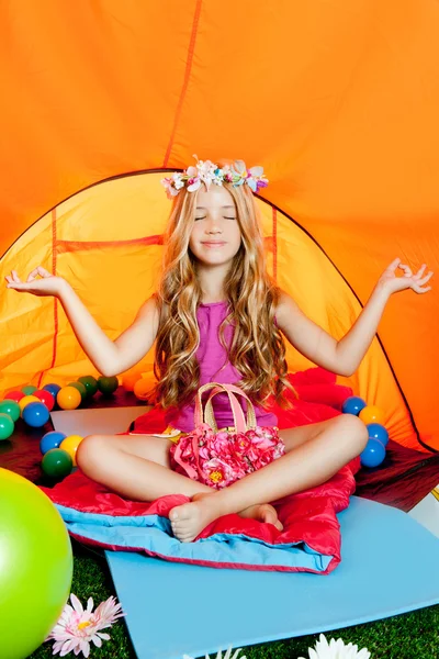 Blond liten flicka utövar yoga i orange camping tält — Stockfoto