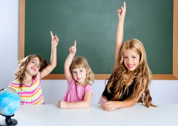 Kids student clever girls in classroom raising hand — Stock Photo, Image