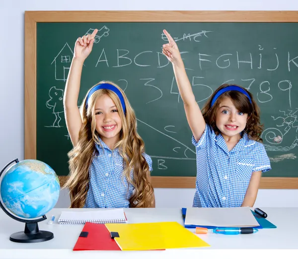 Estudantes inteligentes em sala de aula levantando a mão — Fotografia de Stock