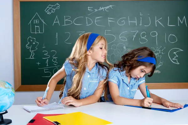Salle de classe avec deux enfants étudiants trichant sur le test — Photo