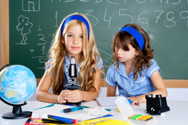 Τα παιδιά τα κορίτσια στο σχολείο στην τάξη με μικροσκόπιο — Φωτογραφία Αρχείου
