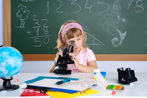 Crianças menina na sala de aula da escola com microscópio — Fotografia de Stock