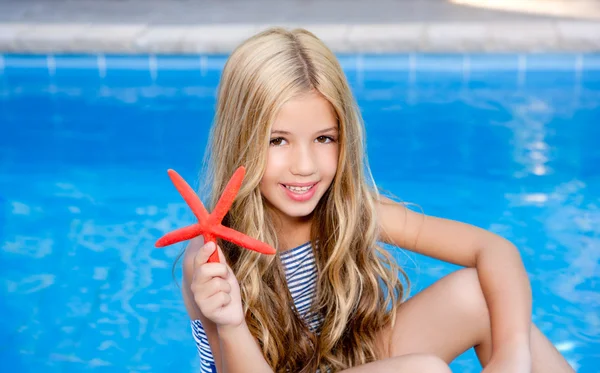Crianças menina loira na piscina de férias de verão estrela do mar — Fotografia de Stock