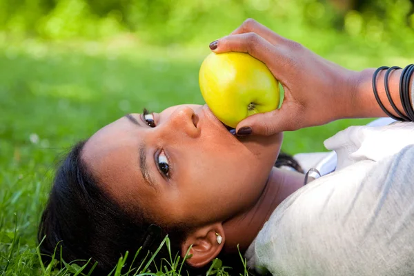 Mulher negra bonita comendo uma maçã — Fotografia de Stock