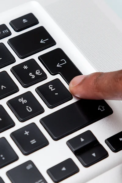Ввод черного пальца на клавиатуре компьютера — стоковое фото