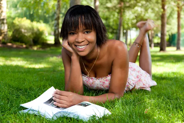 Utomhus porträtt av ung svart kvinna läser en bok — Stockfoto