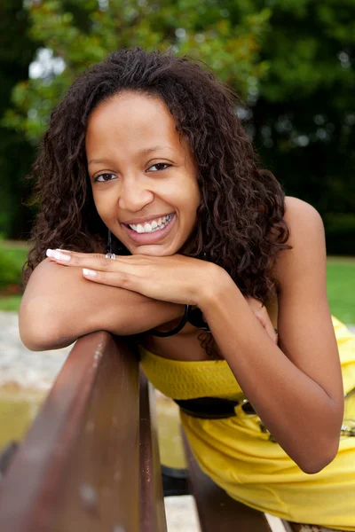 Schöne afrikanisch-amerikanische Frau sitzt auf einer Bank — Stockfoto
