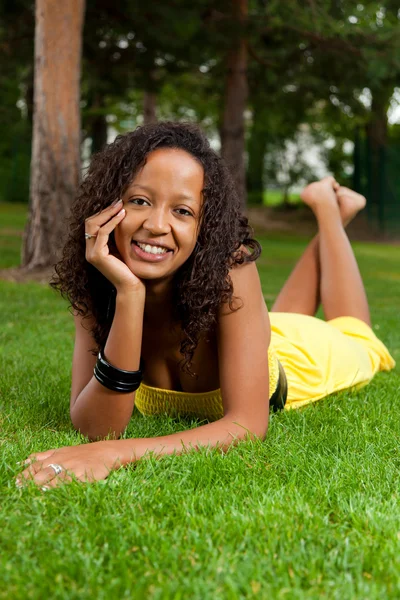 Jeune femme noire couchée sur l'herbe — Photo
