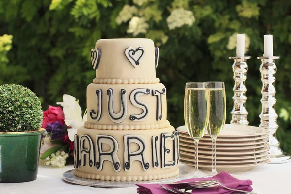 Luxusní svatební dort a dvě sklenice šampaňské flétna — Stock fotografie