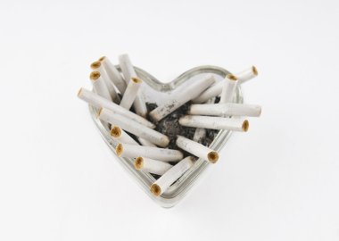 Glass heart with cigarette butts on a white background clipart