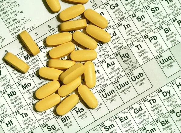 Píldoras sobre tabla de elementos —  Fotos de Stock