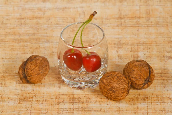 De kleine glazen met rode kers en noten — Stockfoto