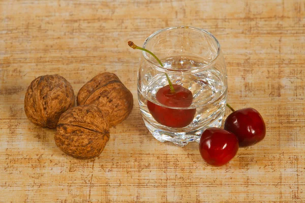 Bodegón con bebidas, cerezas y frutos secos — Foto de Stock