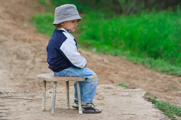 Νεαρό αγόρι κάθεται στην καρέκλα — Φωτογραφία Αρχείου