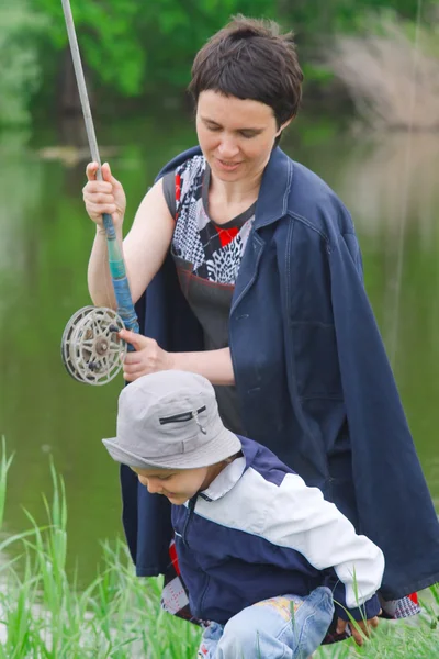 Mother and young son have catch the fish at the river — Stock Photo, Image