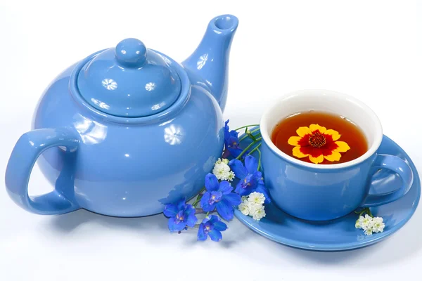 Der blaue Wasserkocher und die Tasse Tee mit Blumen — Stockfoto
