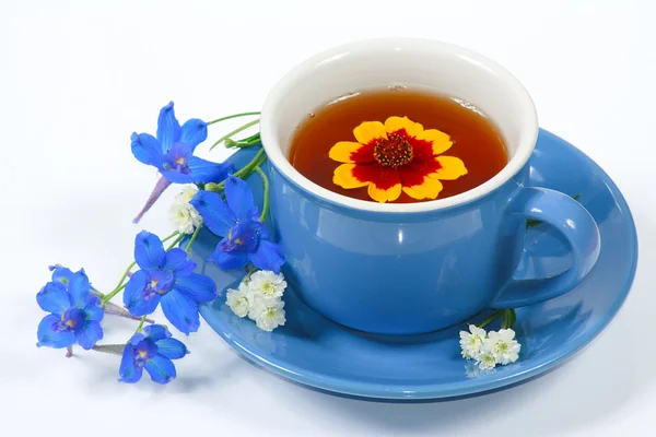 Die blaue Tasse Tee mit Blumen — Stockfoto