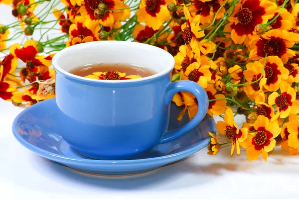 Modrá šálek čaje s květinami — Stock fotografie
