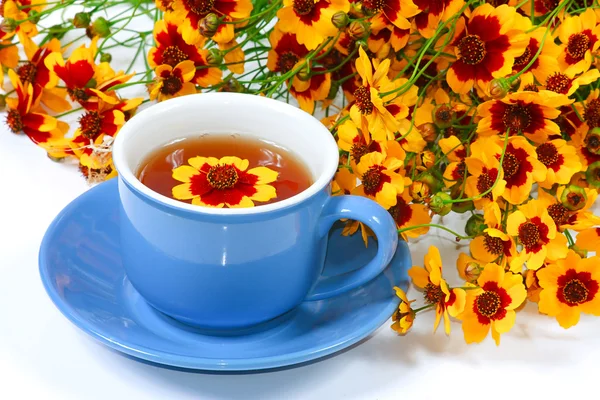 Die blaue Tasse Tee mit Blumen — Stockfoto