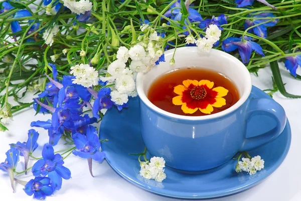 La tasse bleue de thé aux fleurs Image En Vente