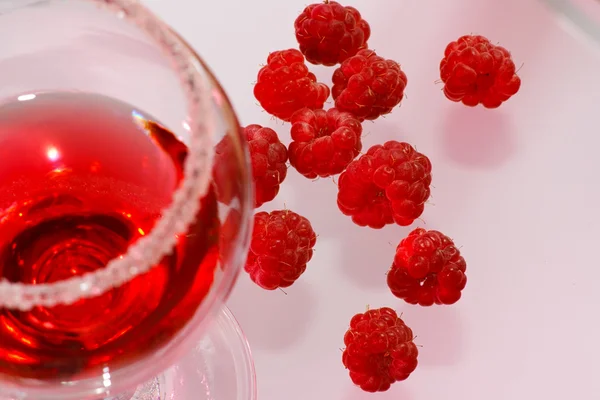 stock image The glass of transparent liquor and raspberry