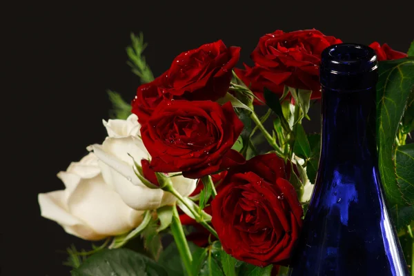 The bouquet red and creamy roses and blue bottle neck — Stock Photo, Image