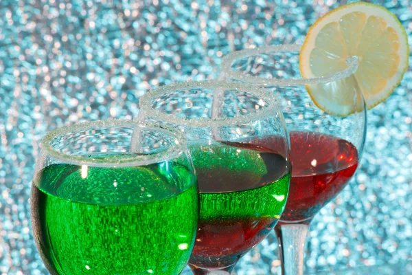 Die drei Gläser grünen und roten Schnaps und Zitrone — Stockfoto