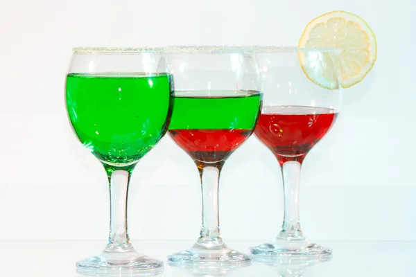 The three glasses of green and red liquor and lemon — Stock Photo, Image