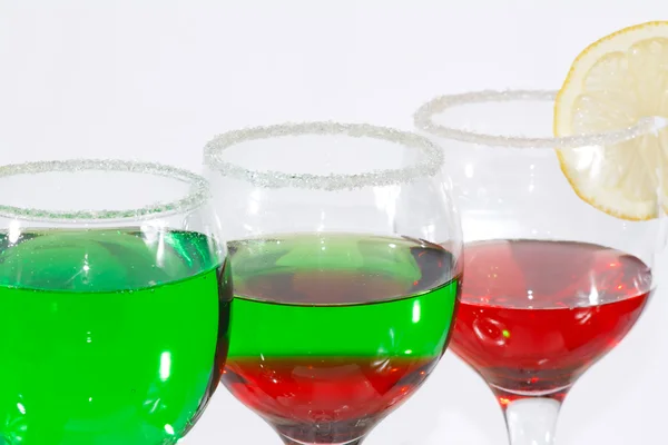 The three glasses of green and red liquor and lemon — Stock Photo, Image