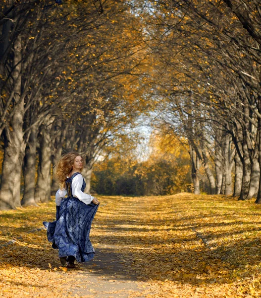Lány öltözött egy retro-stílusú fut az őszi sikátor Jogdíjmentes Stock Képek