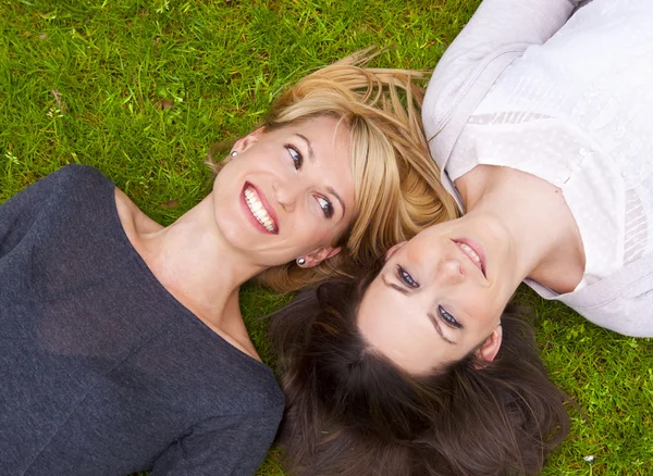 stock image Two girls lying in the grass