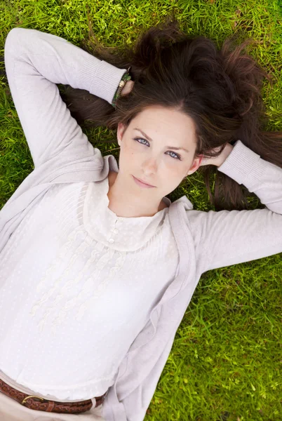 Brunette lying in the grass — Stock Photo, Image