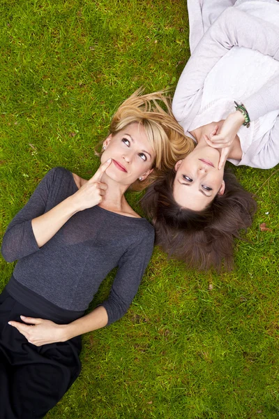 stock image Two girls lying in the grass