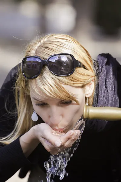 Señora bebiendo agua del grifo — Foto de Stock