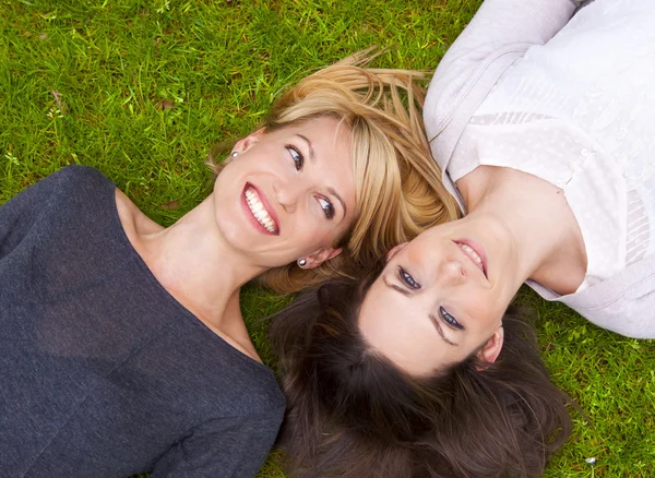 Twee meisjes liggend in het gras — Stockfoto