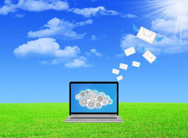Laptop sending email on green field — Stock Photo, Image