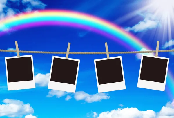 Blank photo frames hanging against rainbow sky — Stock Photo, Image