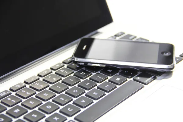 Смартфон на клавіатурі ноутбука — стокове фото