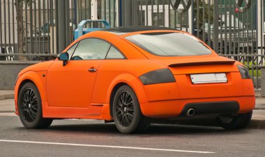 Orange car in the street clipart